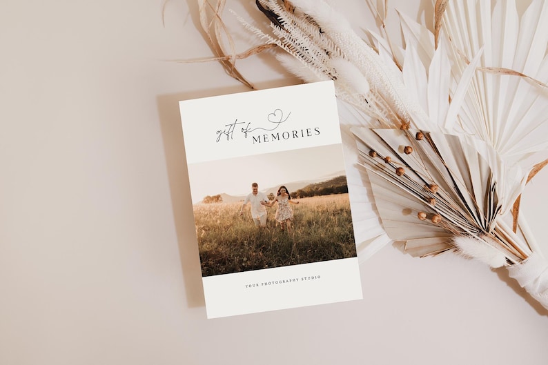 May include: A white card with the text "gift of memories" and a small heart symbol. The card has a photo of a couple and a child walking in a field.