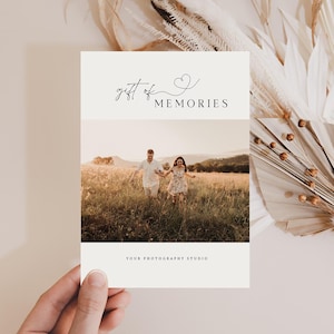 May include: A white card with the text "gift of memories" and a small heart symbol. The card has a photo of a couple holding hands and running through a field of tall grass.