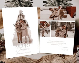 May include: Christmas cards featuring a couple kissing, with a Christmas tree design and the words "MERRY Christmas". The second card has multiple photos of the couple in a snowy setting. The cards are on a brown fabric.