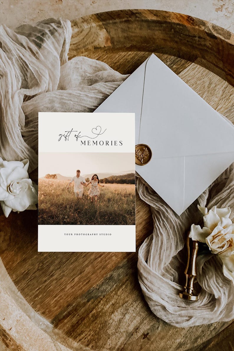 May include: A white card with the text "gift of MEMORIES" and a small heart symbol. The card features a photograph of a couple walking through a field.
