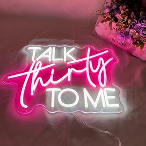 Może przedstawiać: R&oacute;żowy neonowy znak z napisem "Talk Thirty To Me" w białych neonowych literach.