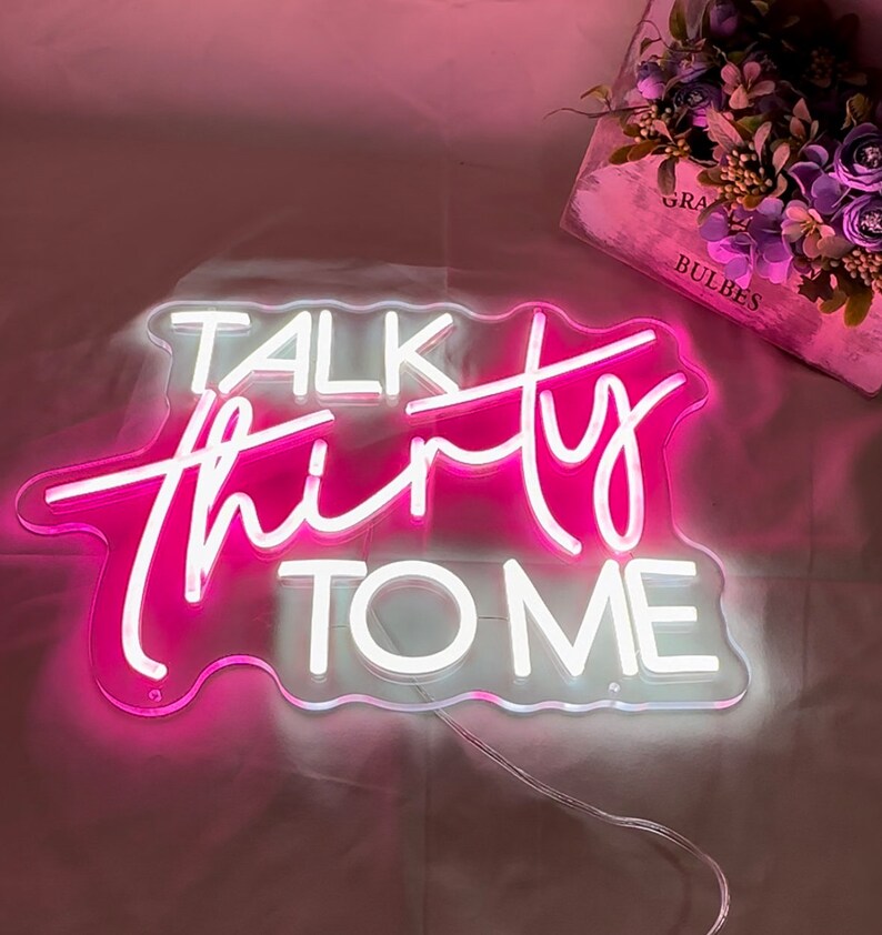 Może przedstawiać: R&oacute;żowy neonowy znak z napisem "Talk Thirty To Me" w białych neonowych literach.