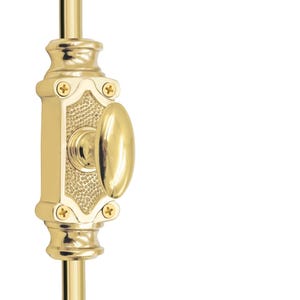 Peut inclure: Un loquet de porte en laiton poli avec une poignée ovale et des détails décoratifs. Le loquet est monté sur une tige verticale en laiton, avec un centre texturé et quatre petites vis.