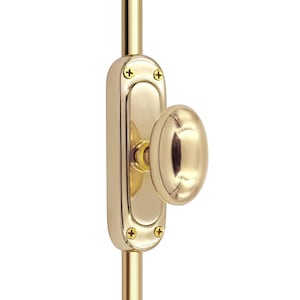 Puede incluir: Un cerrojo de puerta de latón pulido con una placa trasera ovalada y un pomo ovalado. El cerrojo está montado en una varilla vertical de latón y asegurado con cuatro tornillos de latón. La ferretería tiene un acabado brillante y reflectante.