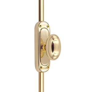 Puede incluir: Un cerrojo de puerta de latón pulido con una placa trasera ovalada y un tirador ovalado. El cerrojo está montado sobre una varilla vertical de latón. El diseño presenta cuatro tornillos pequeños que aseguran la placa trasera.