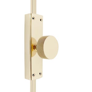 May include: A gold door knob with a textured round handle. The knob is attached to a gold metal plate.
