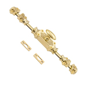 May include: A gold-coloured door bolt with decorative detailing. The bolt features an oval handle and two matching strike plates. The design includes ornate accents and is made of a shiny, metallic material. Ideal for home decor and hardware.