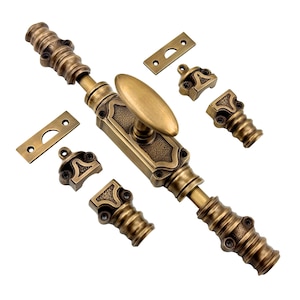 Könnte beinhalten: Antikes Schrankriegel-Set in Messingoptik. Das Set enthält einen verzierten Riegel mit ovalem Griff, zwei rechteckige Platten und vier dekorative Montageteile. Die Hardware hat eine Vintage-Ästhetik.