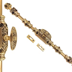 May include: An ornate brass window fastener set, including a lever, handle, and two strike plates. The pieces are decorated with detailed floral and scrollwork. The hardware has a warm gold finish, suggesting an antique style.