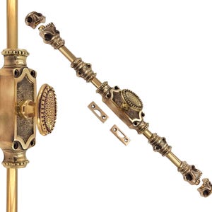 Könnte beinhalten: Verziertes Türbeschlagsset aus Messing mit einem Totenkopf-Motiv-Riegel und einer dekorativen Türplatte mit ovalem Knauf. Das Set enthält einen langen Riegel mit Totenkopfakzenten.