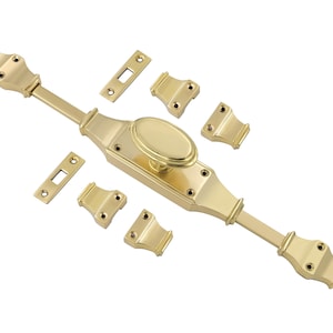 May include: Brass window latch set with a decorative oval handle and a long, straight arm. The set includes multiple pieces for installation.