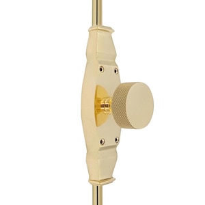 Puede incluir: Un pomo de puerta de latón pulido con un diseño acanalado. El pomo está unido a una manilla de puerta de latón con un diseño decorativo y ornamentado.