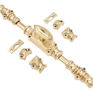 Puede incluir: Un juego de cerrojo de puerta dorado con detalles decorativos. El juego incluye el cerrojo principal, dos placas de cierre y varias piezas decorativas. El cerrojo presenta un mango ovalado y diseños ornamentados, adecuado para la decoración del hogar.
