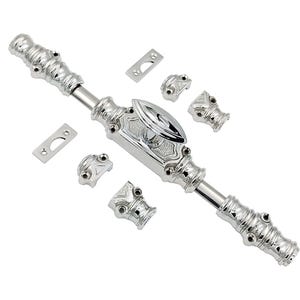 Op de afbeelding: Een zilveren deurgrendel met sierlijke details en een decoratieve knop. De grendel bestaat uit verschillende onderdelen, waaronder twee eindkappen, een centrale knop en een lange, cilindrische stang.