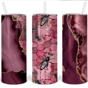 May include: Three stainless steel tumblers with a pink and gold agate design. The centre tumbler features a bee and honeycomb pattern with vintage text.