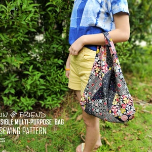 May include: A reversible multi-purpose bag with a patchwork design, featuring floral and geometric patterns in various colors. The bag is held by a person. Text on the image reads: "MALIN AND FRIEND REVERSIBLE MULTI-PURPOSE BAG PDF SEWING PATTERN 3 Sizes."