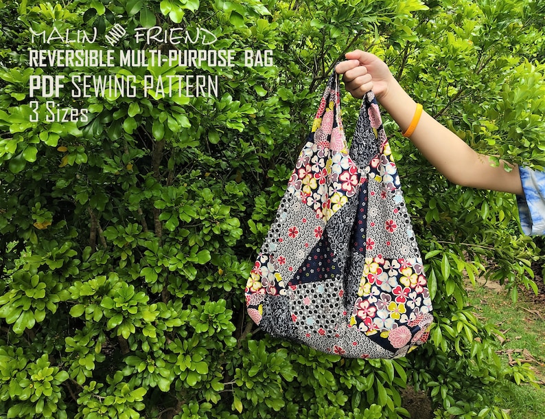 May include: A reversible multi-purpose bag with a floral patchwork design. The bag is held up by a person's hand. The text on the image reads: "MALIN AND FRIEND REVERSIBLE MULTI-PURPOSE BAG PDF SEWING PATTERN 3 Sizes."