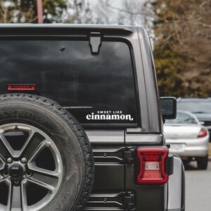 May include: A black Jeep with a white sticker on the back window that says "Sweet Like Cinnamon".