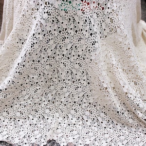 Puede incluir: Tela de crochet blanca con un delicado patrón floral. La tela es suave y ligera, lo que la hace ideal para una variedad de proyectos de manualidades.