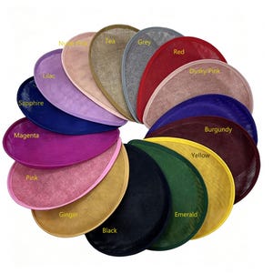 Peut inclure: Une collection de bases de bibi semi-circulaires disposées en éventail, présentant des couleurs étiquetées Nude Pink, Tea, Grey, Red, Dusky Pink, Burgundy, Yellow, Emerald, Black, Ginger, Pink, Magenta, Sapphire et Lilac avec une texture en maille.