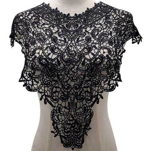 Pode incluir: Bordado de renda preta com uma borda festoneada e um padrão floral intrincado. Este bordado é perfeito para adicionar um toque de elegância a qualquer projeto.