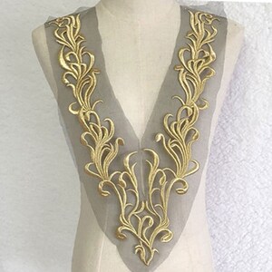 May include: Gold embroidered lace trim with a delicate floral design, perfect for adding a touch of elegance to clothing or crafts.