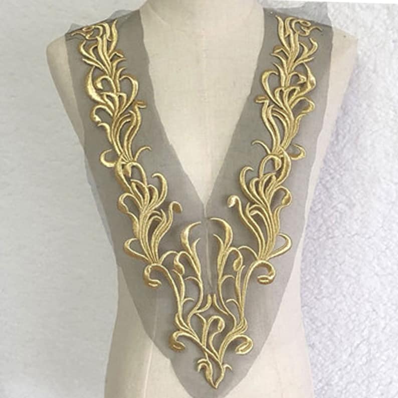 May include: Gold embroidered lace trim with a delicate floral design, perfect for adding a touch of elegance to clothing or crafts.