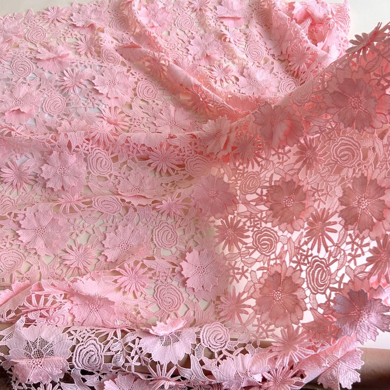 Pu&ograve; includere: Tessuto di pizzo floreale rosa con un design delicato e intricato. Il pizzo presenta una variet&agrave; di forme e dimensioni di fiori, creando un look bellissimo e femminile.