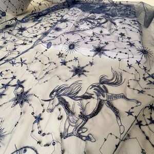 May include: Black tulle fabric with embroidered stars and a unicorn design. The fabric is embellished with sequins.