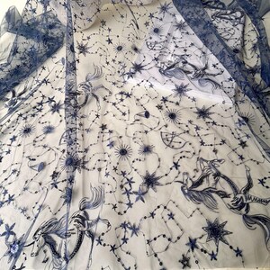 May include: Blue tulle fabric with a white background and an embroidered design of stars, constellations, and horses.