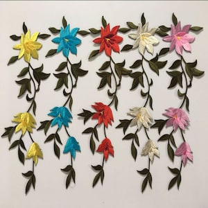 May include: Assortment of embroidered iron-on patches featuring floral designs in various colours, including yellow, blue, red, white, and pink. Each patch depicts a vine with multiple flowers.