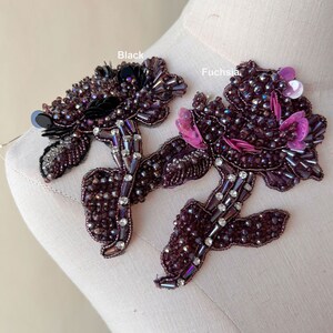 Pode incluir: Duas aplicações florais com contas em tons de roxo, preto e fúcsia. As aplicações apresentam intrincados trabalhos de contas, lantejoulas e detalhes de cristal. O texto "Black" e "Fuchsia" é visível na imagem.