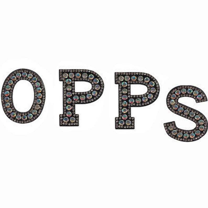 Puede incluir: La palabra "OPPS" escrita en letras negras con diamantes de imitaci&oacute;n iridiscentes.
