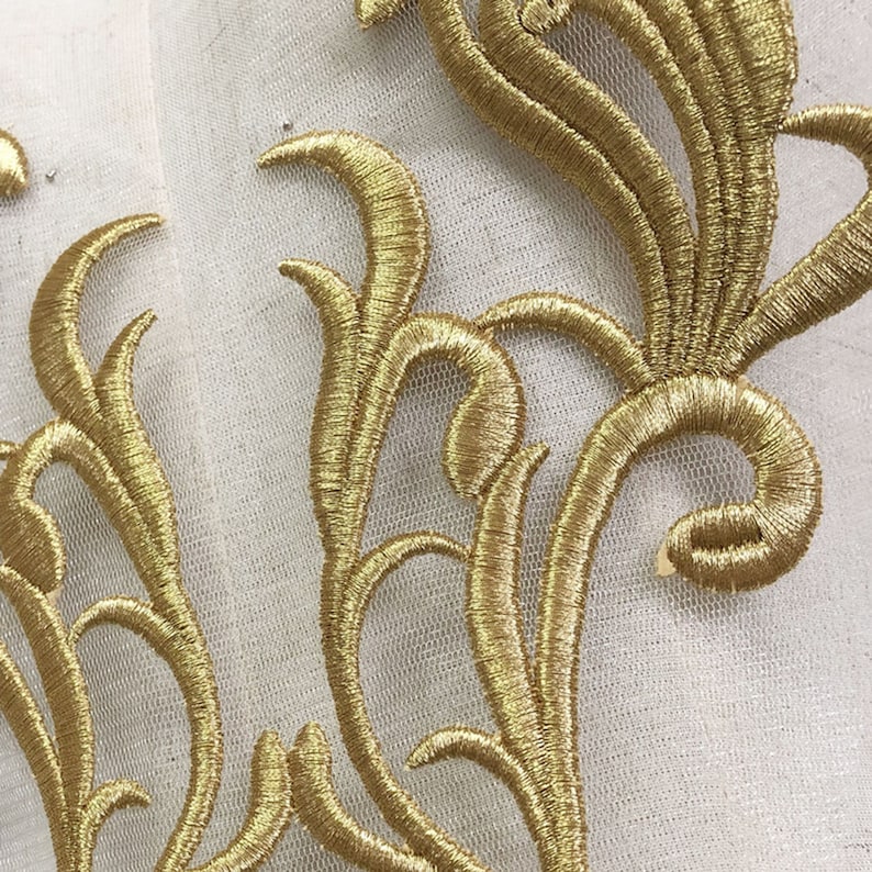 May include: Gold embroidered lace applique with a floral design. The lace is delicate and intricate, with a variety of swirls and curves. It would be perfect for adding a touch of elegance to any project.