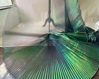 Peut inclure: Un morceau de tissu irisé présentant une texture finement plissée en accordéon. Le matériau affiche un effet de changement de couleur, passant du vert émeraude profond au gris anthracite foncé selon la lumière, avec un éclat métallique.
