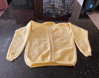 Cárdigan de niña de color amarillo.