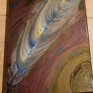May include: Abstract painting on canvas with a swirling design in shades of gold, brown, blue, and white. The design resembles a feather.