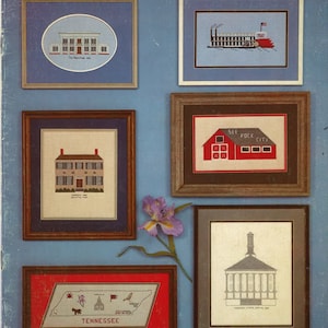 May include: A vintage craft pattern book titled "Tennessee Nostalgia" by the Turnip Patch. The cover features framed cross-stitch designs of Tennessee landmarks, including a steamboat, a barn, and the state capitol building. The color palette includes blue, red, and brown.