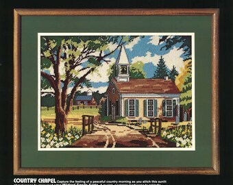 May include: A framed needlepoint kit titled "Country Chapel" featuring a quaint landscape with a church, trees, and a pathway. The kit includes Persian wool yarn, cotton embroidery thread, and instructions. The frame size is 16"x12" (40x30cm).