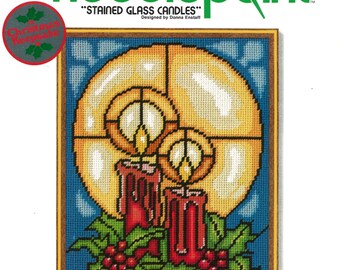 May include: Needlepoint kit titled "Stained Glass Candles" featuring a design of two red candles with flames and holly berries. The kit includes 100% wool yarn, a needle, and instructions. It fits a 9 x 12 inch frame.