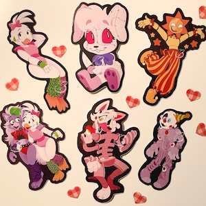 May include: Set of 7 colorful cartoon character stickers featuring a pink and white bunny, a purple and green wolf, a pink and white chicken, a purple and white clown, a pink and white robot, a pink and white chicken, and a yellow and red sun character.
