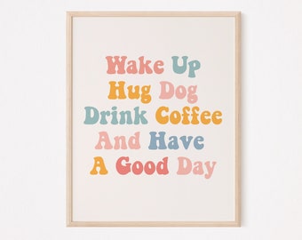 May include: A framed print with a white background and colorful text that reads "Wake Up Hug Dog Drink Coffee And Have A Good Day".