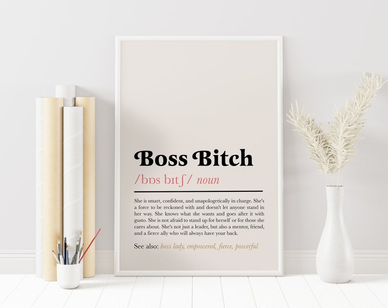 Peut inclure: Une affiche imprimable avec un fond beige et du texte noir. Le texte dit "Boss Bitch /bDs bitf/ noun" et d&eacute;finit le terme comme une personne intelligente, confiante et qui assume ses responsabilit&eacute;s. Le texte comprend &eacute;galement "Voir aussi : boss lady, empowered, fierce, powerful".