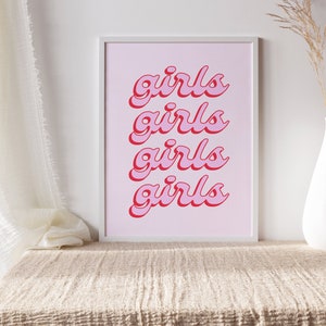 May include: A framed print with a pink background and the word "girls" repeated four times in a red, cursive font.