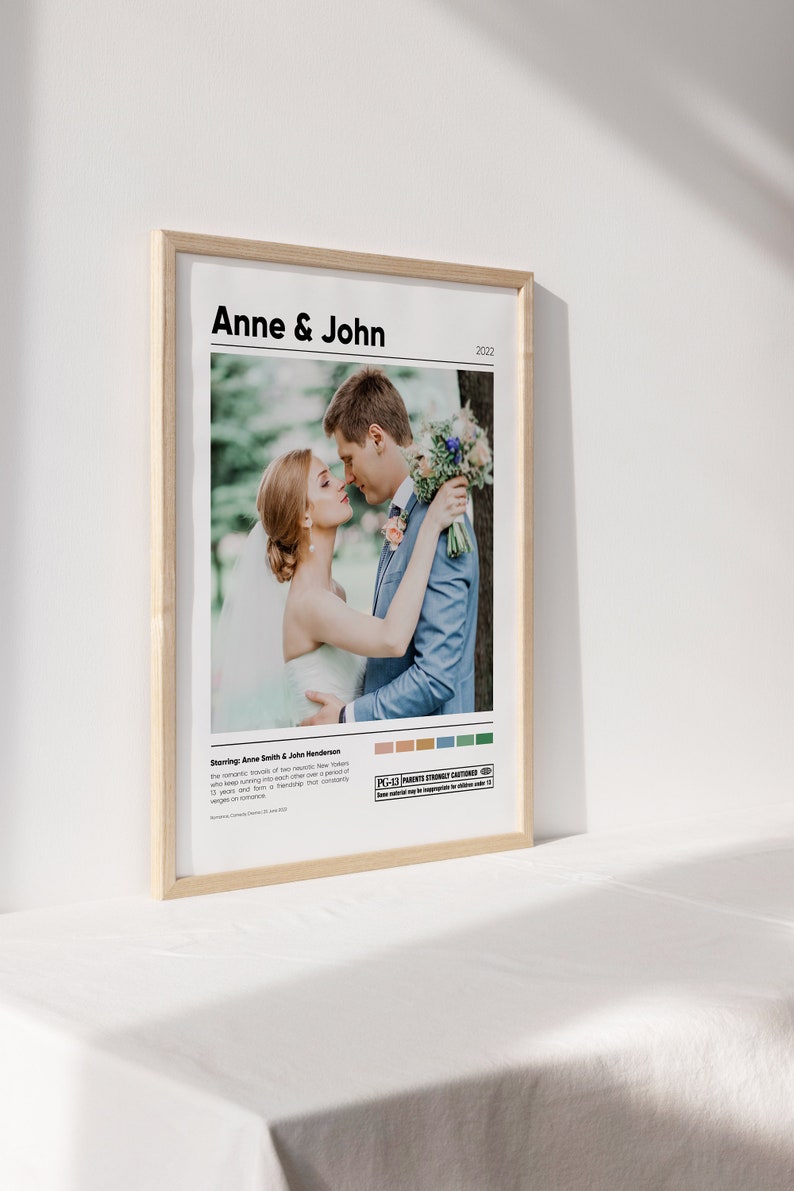 May include: A wedding poster with a photo of a couple kissing, the text "Anne & John" and the year "2022". The poster has a movie poster style with a color palette and a "PG-13 Parents Strongly Cautioned" rating.