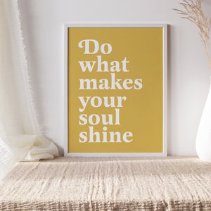Peut inclure: Une impression encadr&eacute;e jaune avec du texte blanc qui dit "Do what makes your soul shine". L'impression est pos&eacute;e sur une table beige avec un vase blanc et des fleurs s&eacute;ch&eacute;es.