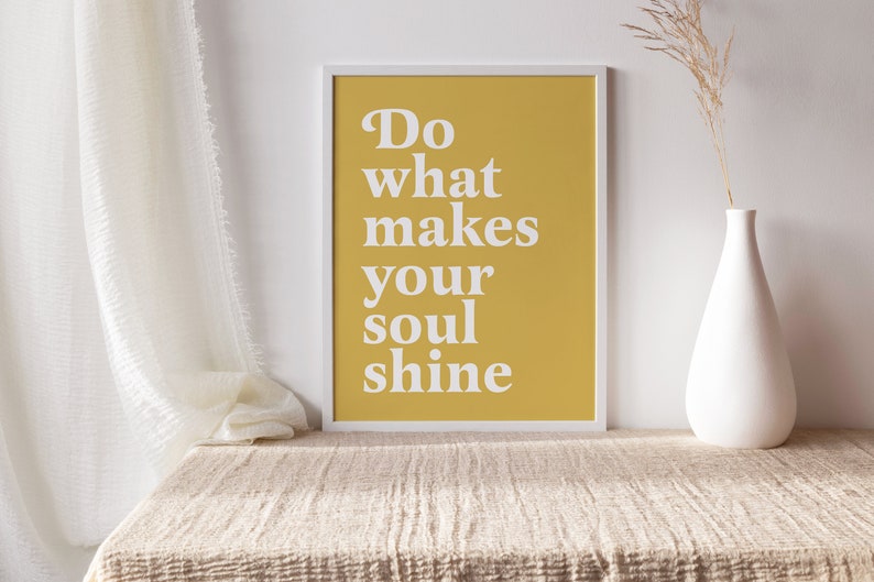 Peut inclure: Une impression encadr&eacute;e jaune avec du texte blanc qui dit "Do what makes your soul shine". L'impression est pos&eacute;e sur une table beige avec un vase blanc et des fleurs s&eacute;ch&eacute;es.