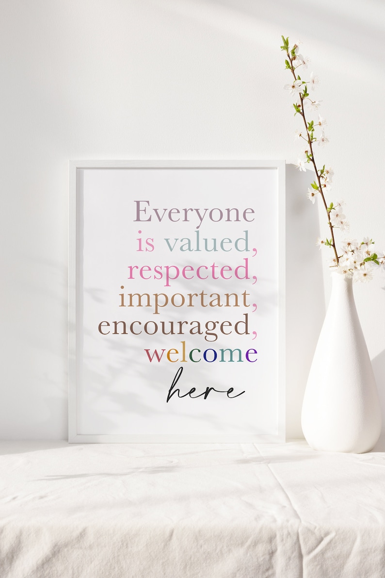 K&ouml;nnte beinhalten: Ein wei&szlig;er gerahmter Druck mit dem Text "Everyone is valued, respected, important, encouraged, welcome here" in bunten Farben auf wei&szlig;em Hintergrund.