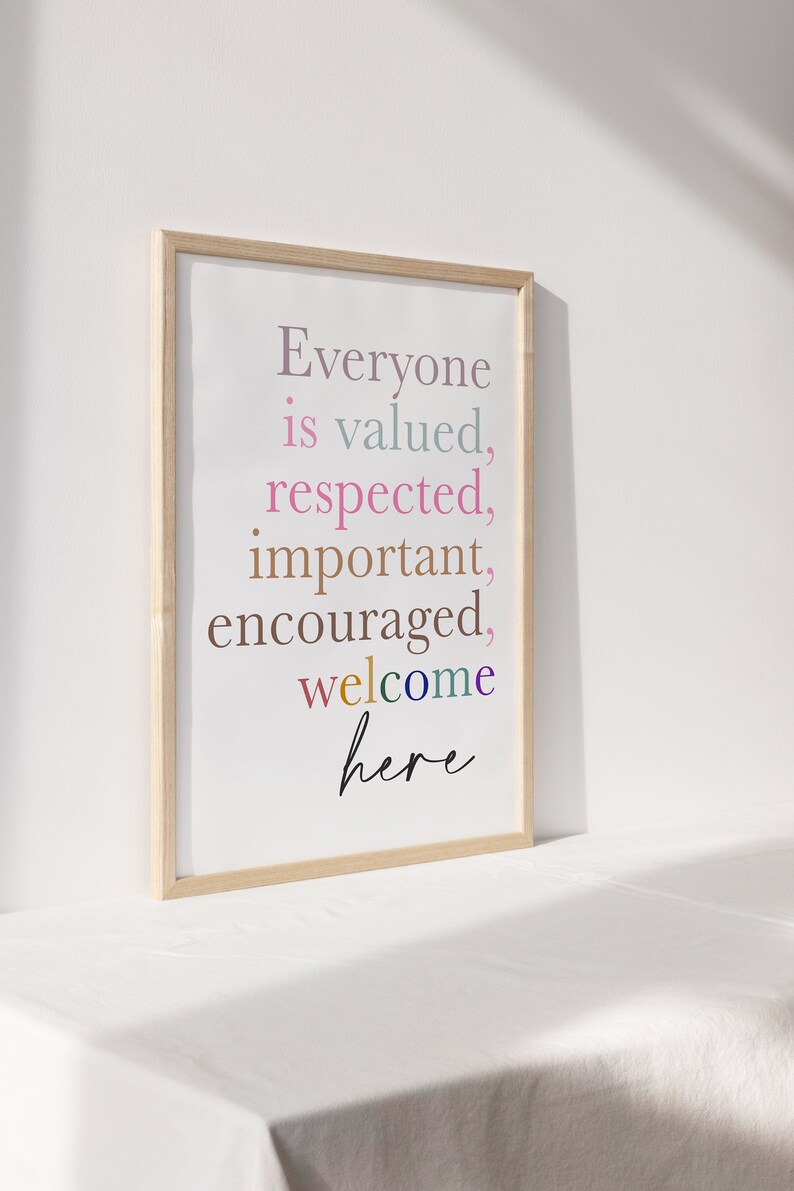 K&ouml;nnte beinhalten: Ein gerahmter Druck mit dem Text "Everyone is valued, respected, important, encouraged, welcome here" in verschiedenen Farben. Der Rahmen ist aus hellem Holz.