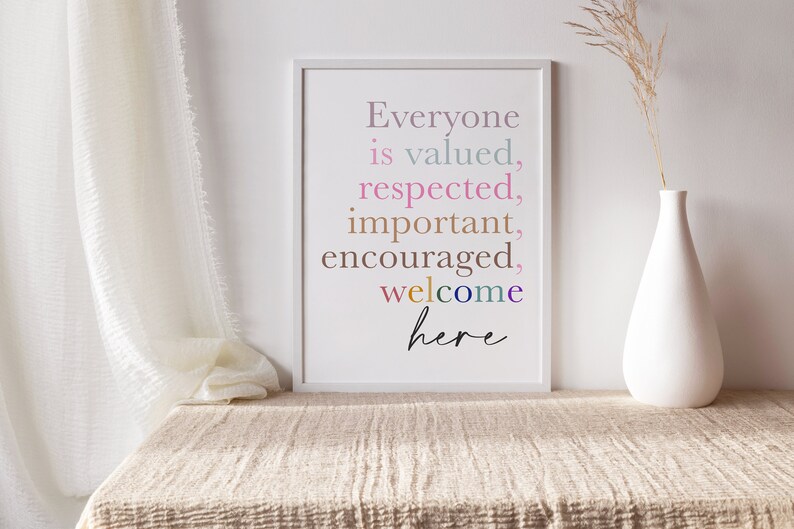 K&ouml;nnte beinhalten: Ein wei&szlig;er gerahmter Druck mit dem Text "Everyone is valued, respected, important, encouraged, welcome here" in bunten Buchstaben auf wei&szlig;em Hintergrund.